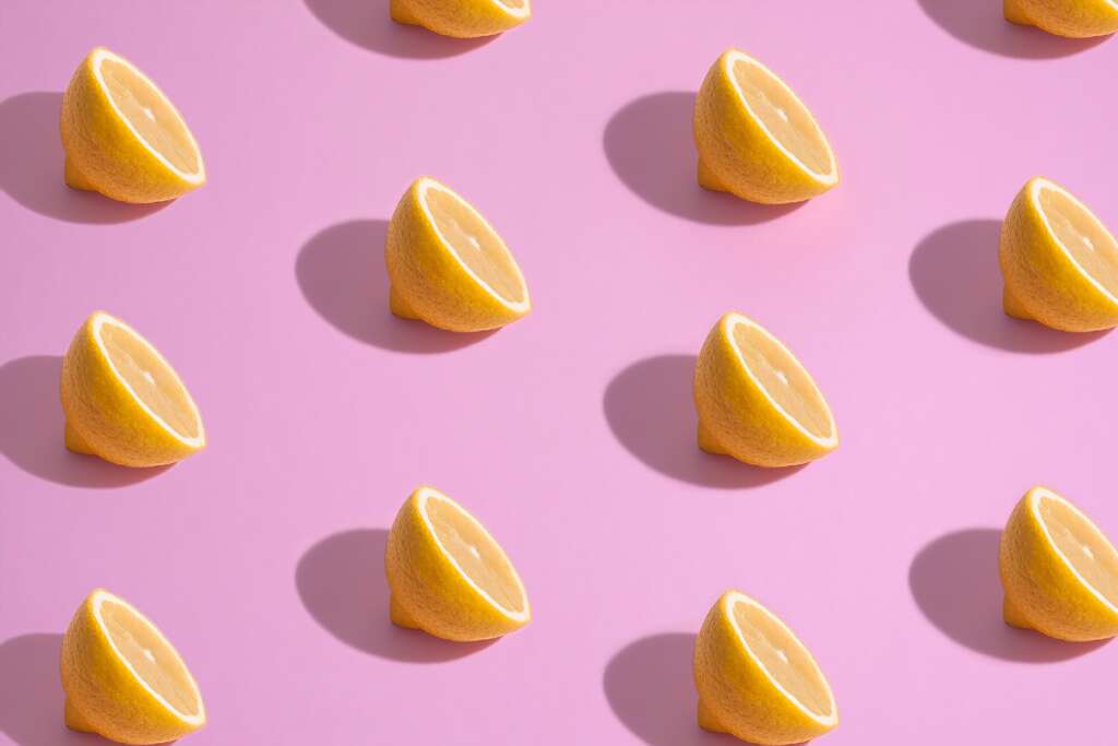 Halved lemons on a pink background